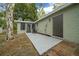 A spacious backyard featuring a patio and the exterior of a single-story home with a screened-in porch at 9613 River Rd, Spring Hill, FL 34608