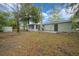 Backyard of home featuring mature trees and green grass at 9613 River Rd, Spring Hill, FL 34608