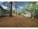 A serene backyard with mature trees and the exterior of a single-story home with a wooden shed at 9613 River Rd, Spring Hill, FL 34608
