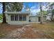 A serene backyard featuring an enclosed porch and direct access to the main house, with lush natural surroundings at 9613 River Rd, Spring Hill, FL 34608