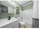 Updated bathroom with modern fixtures, green walls, vanity and tiled shower at 9613 River Rd, Spring Hill, FL 34608