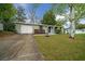 View of a single-story home with an attached garage and a concrete driveway at 9613 River Rd, Spring Hill, FL 34608