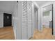 Hallway with closet, wood-look floors and access to the front door and bathroom at 9613 River Rd, Spring Hill, FL 34608