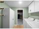 Laundry room with washer, dryer, storage cabinets, and doorway to basement at 9613 River Rd, Spring Hill, FL 34608