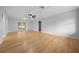 Large open-concept living room with sliding glass doors and ceiling fan at 9613 River Rd, Spring Hill, FL 34608