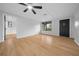 Open living room with wood-look floors, ceiling fan, and natural light from the window at 9613 River Rd, Spring Hill, FL 34608