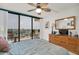 Bright bedroom with a ceiling fan, dresser, and balcony access overlooking a waterfront view at 1 Key Capri # 502E, Treasure Island, FL 33706