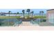Scenic community view with stairs, railing, lawn, shuffleboard, and distant waterfront at 1 Key Capri # 502E, Treasure Island, FL 33706