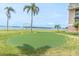A putting green featuring gulf views offers a dedicated space for golf practice and leisure at 1 Key Capri # 502E, Treasure Island, FL 33706