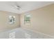 Bright bedroom with white tile floors, ceiling fan, and natural light from two windows at 1020 W Berry Ave, Tampa, FL 33603