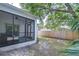A spacious backyard featuring a screened-in patio, privacy fence, and mature trees offers a relaxing outdoor space at 1051 44Th S St, St Petersburg, FL 33711