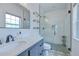 Modern bathroom with glass shower door, gray cabinets, and a large vanity mirror at 1051 44Th S St, St Petersburg, FL 33711