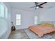 Bright bedroom featuring wood floors, three windows with blinds, and a ceiling fan with light at 1051 44Th S St, St Petersburg, FL 33711
