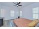 Bright bedroom featuring wood floors, three windows with blinds, and a ceiling fan with light at 1051 44Th S St, St Petersburg, FL 33711