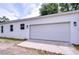 A detached two-car garage featuring a pristine white exterior and a driveway, adding to the property's appeal at 1051 44Th S St, St Petersburg, FL 33711