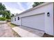 A detached two-car garage with a fresh white exterior and a concrete driveway seamlessly blends with the property at 1051 44Th S St, St Petersburg, FL 33711
