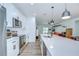 Modern kitchen featuring white cabinets, stainless steel appliances, and a quartz countertop island at 1051 44Th S St, St Petersburg, FL 33711