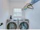 Modern laundry room featuring a side-by-side washer and dryer and shelving for storage at 1051 44Th S St, St Petersburg, FL 33711