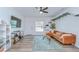 Bright living room featuring hardwood floors, TV, comfortable seating, and modern ceiling fan at 1051 44Th S St, St Petersburg, FL 33711