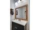 Bathroom features a vanity with modern finishes, white countertop, black cabinets, and custom wood-framed mirror at 10636 Dawns Light Dr, Riverview, FL 33578