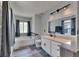 Bathroom featuring gray floors, vanity with drawers, toilet, and soaking tub under a window at 10636 Dawns Light Dr, Riverview, FL 33578