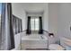 Bathtub with window, gray towel hanging from the shower curtain rod and gray floors at 10636 Dawns Light Dr, Riverview, FL 33578