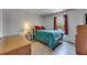 Cozy bedroom featuring wood-look flooring and a bright window with dark red curtains at 10636 Dawns Light Dr, Riverview, FL 33578