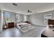 Open bedroom with wood-look flooring, three windows, ceiling fan and a queen size bed at 10636 Dawns Light Dr, Riverview, FL 33578