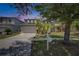 Desirable two-story home featuring a wide driveway, two-car garage, mature trees, and tropical plants at 10636 Dawns Light Dr, Riverview, FL 33578