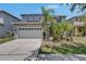 Attractive two-story home boasting a spacious driveway, attached two-car garage, and verdant tropical landscaping at 10636 Dawns Light Dr, Riverview, FL 33578