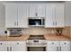 Modern kitchen with white cabinetry, stainless steel appliances, and tiled backsplash at 10636 Dawns Light Dr, Riverview, FL 33578