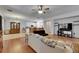 Open-concept living room features hardwood floors, ceiling fan, and flows into the modern kitchen with breakfast bar at 10636 Dawns Light Dr, Riverview, FL 33578