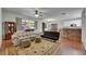 Bright living room with large window, area rug, hardwood floors and open access to the dining and kitchen areas at 10636 Dawns Light Dr, Riverview, FL 33578