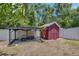 Red tool shed in the backyard with concrete foundation and gravel around the shed at 10636 Dawns Light Dr, Riverview, FL 33578