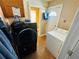 A laundry room equipped with a modern black washing machine and a traditional white dryer at 1101 Alcazar S Way, St Petersburg, FL 33705