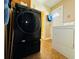 Laundry room featuring modern black washing machine and classic white dryer near an exterior door at 1101 Alcazar S Way, St Petersburg, FL 33705