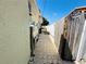 Narrow side yard with a paver walkway leading to the backyard, enclosed by wooden and white fences at 1101 Alcazar S Way, St Petersburg, FL 33705