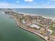Stunning aerial view of the coastal town with white buildings next to a beach, ocean and a pier on a sunny day at 1104 Pass A Grille Way, St Pete Beach, FL 33706