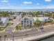 An exterior showcases a three-story beach house, white columns, and balconies, offering stunning coastal living at 1104 Pass A Grille Way, St Pete Beach, FL 33706