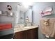 Bathroom featuring vanity with granite counter, storage shelves and modern mirror at 11314 Silverleaf Ct, Riverview, FL 33579
