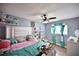 Charming bedroom featuring a ceiling fan, blue walls, wood floor, and plenty of decor at 11314 Silverleaf Ct, Riverview, FL 33579