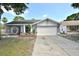 Charming single-story home with a well-manicured lawn, a two-car garage, and a welcoming front porch area at 11314 Silverleaf Ct, Riverview, FL 33579