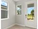 Bright foyer featuring tile floors and a view of the landscaped front yard through the glass front door at 11359 Boundless Ter, Venice, FL 34293