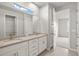 Bright bathroom featuring double vanity with light countertops and a doorway to a bedroom at 11375 Boundless Ter, Venice, FL 34293