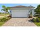 Garage and patterned driveway in front of a two-car garage with manicured landscaping at 11375 Boundless Ter, Venice, FL 34293