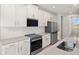 Modern kitchen featuring stainless steel appliances, white cabinets, and light countertops at 11375 Boundless Ter, Venice, FL 34293