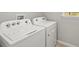 White washer and dryer set in a laundry room with neutral walls and a window, providing a clean space at 11375 Boundless Ter, Venice, FL 34293