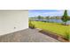 Paver patio by lush lawn and lake, offers a serene outdoor space with peaceful water views and landscaping at 11375 Boundless Ter, Venice, FL 34293