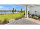 Paver patio overlooking a lush lawn, lake, and trees, offering serene outdoor living and scenic views at 11375 Boundless Ter, Venice, FL 34293