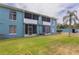View of the back of a teal building showing well-maintained lawn and screened in patios at 11404 2Nd N St # 3, St Petersburg, FL 33701